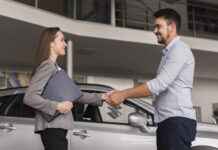 Acheter une voiture d’occasion : comment éviter les mauvaises surprises ? lateral-view-young-man-shaking-hands-with-car-dealer
