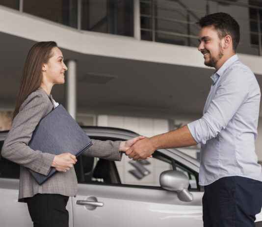 Acheter une voiture d’occasion : comment éviter les mauvaises surprises ? lateral-view-young-man-shaking-hands-with-car-dealer